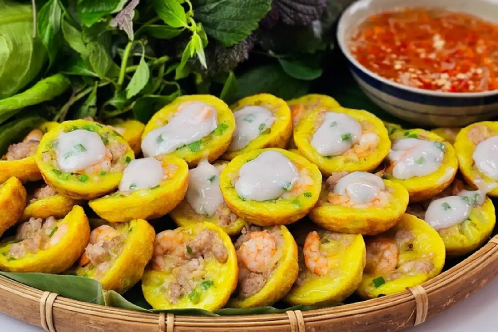 Bánh khọt giòn rụm nhân tôm thịt, vỏ mỏng từ bột gạo tẻ, rau sống.